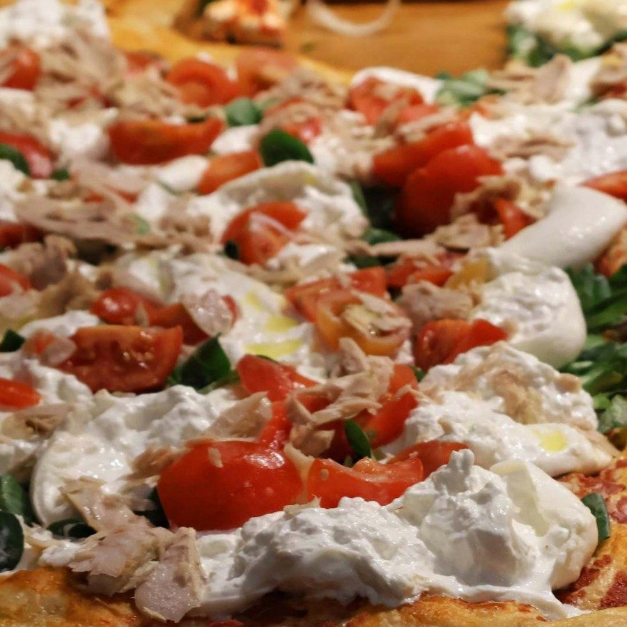 Dettaglio pizza al trancio Crancio con tonno, burrata e pomodorino