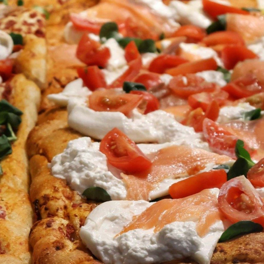 Dettaglio pizza al trancio Crancio con salmone, burrata e pomodorino